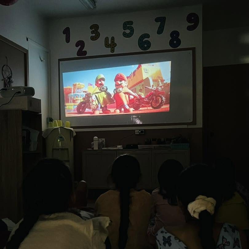 Les enfants regardent un film projeté au centre
